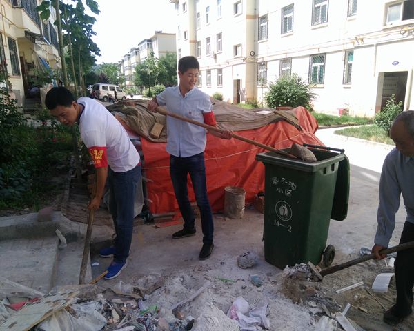 社區(qū)黨員志愿者幫助小區(qū)居民清理垃圾雜物